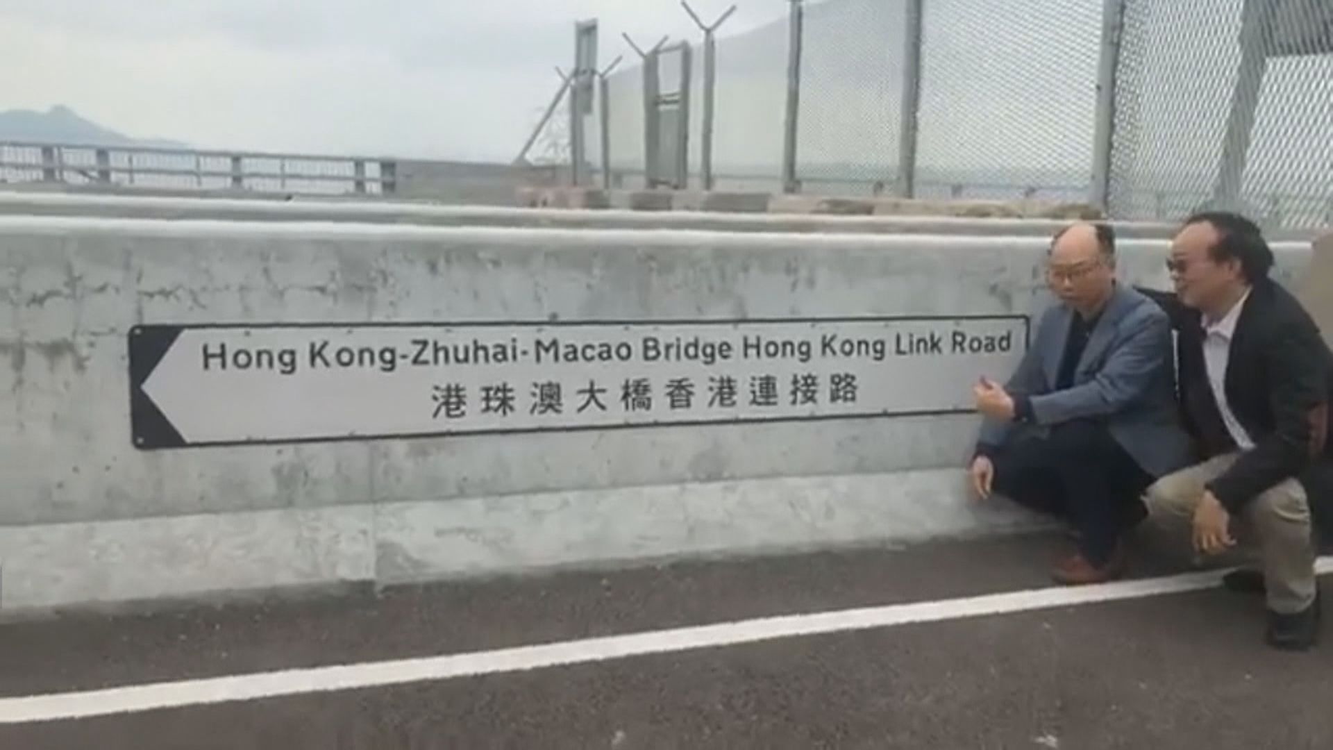 陳帆跟議員在大橋粵港分界線前的路牌合照
